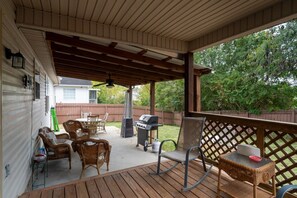 A covered patio with outdoor furniture, a grill, and a view of a backyard. - Quiet neighborhood home with private patio, free parking & easy airport access (Nashville)