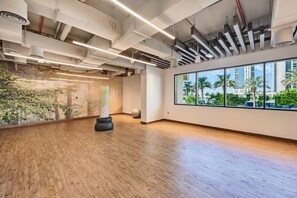 A spacious room with a large window, wooden flooring, and a punching bag. - Stylish 1BR - Creek Harbour - Pool, Gym & Parking (Dubai)