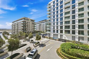A modern apartment complex with multiple floors, balconies, and a landscaped courtyard. - Stylish 1BR - Creek Harbour - Pool, Gym & Parking (Dubai)