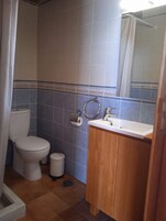 Un baño con inodoro, lavabo y cortina de ducha.