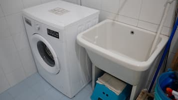 A compact laundry area with a washing machine and a sink.
