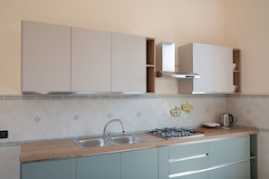 Una cocina con lavabo, estufa y armarios.