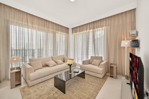Un salon moderne avec un canapé, une table basse et un téléviseur.