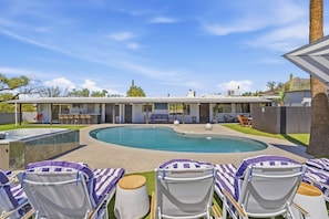 A pool area with lounge chairs and a building in the background. - Spectacular Retreat with Private Pickleball Court (Tucson)