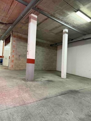 A parking garage with concrete pillars and a brick wall. - Apartment 'Burriana Bliss Nerja' with Mountain View, Wi-Fi and Air Conditioning (Nerja)