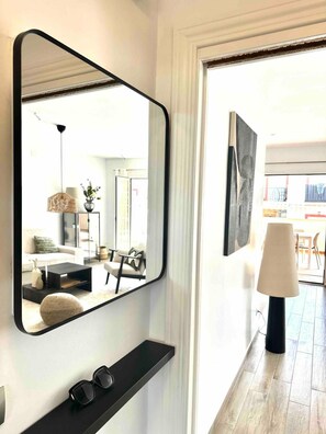 A modern interior with a large mirror, a black console table, and a floor lamp. - Apartment 'Burriana Bliss Nerja' with Mountain View, Wi-Fi and Air Conditioning (Nerja)