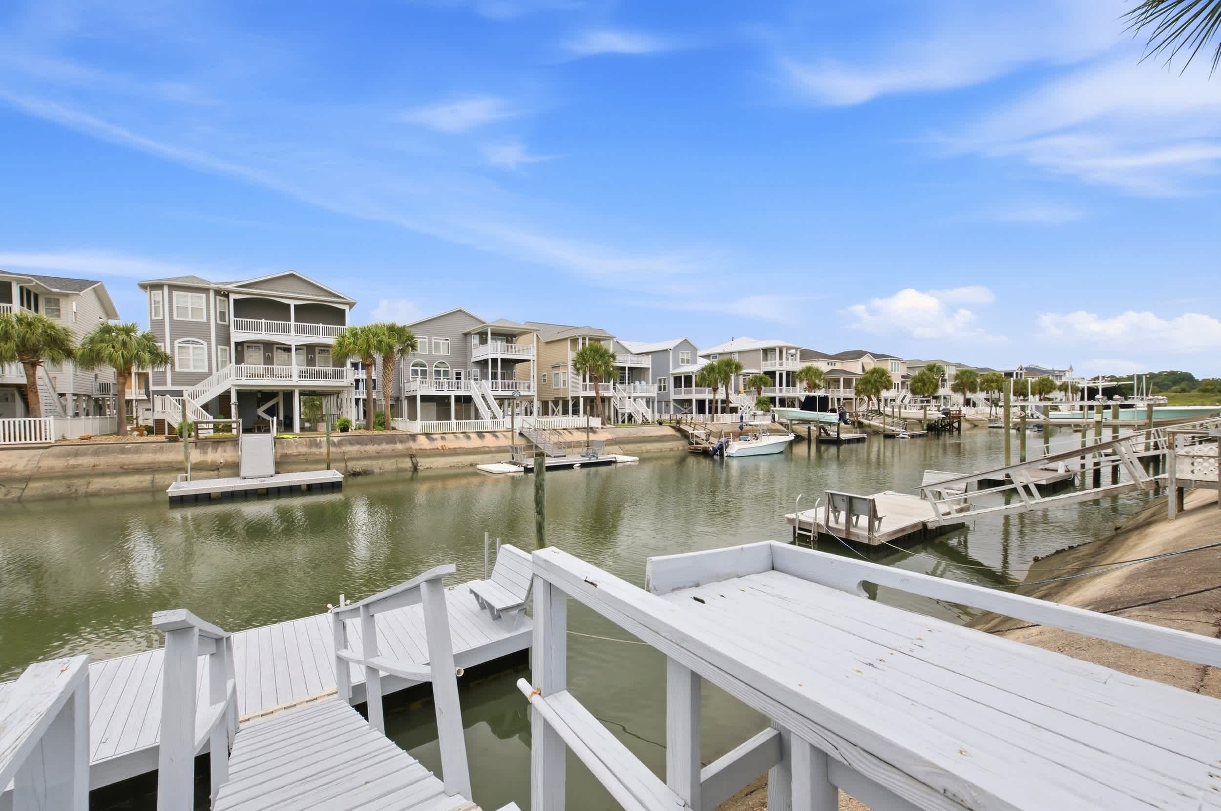 A waterfront property with multiple-story buildings, docks, and boats.