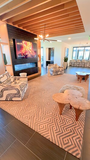 A modern living room with a fireplace, patterned rug, and contemporary furniture. - Midtown Atlanta Luxury 1BR Skyline Views, Pool & Gym (Atlanta)