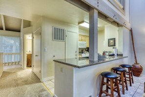 A kitchen with a bar area, stools, and a large mirror. - Lake days, mountain adventures & resort amenities right outside your door (South Lake Tahoe)
