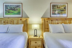 A hotel room with two beds, a nightstand with a lamp, and two framed golf course paintings on the walls. - Lake days, mountain adventures & resort amenities right outside your door (South Lake Tahoe)