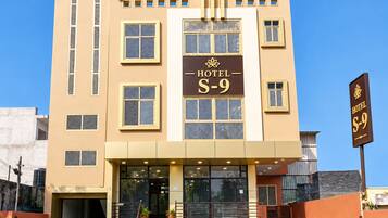Um hotel com uma placa indicando 'HOTEL S-9' e uma escadaria que leva à entrada.