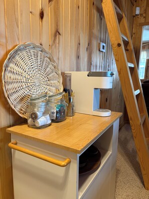 A kitchen counter with a woven basket, jars, and a coffee maker.