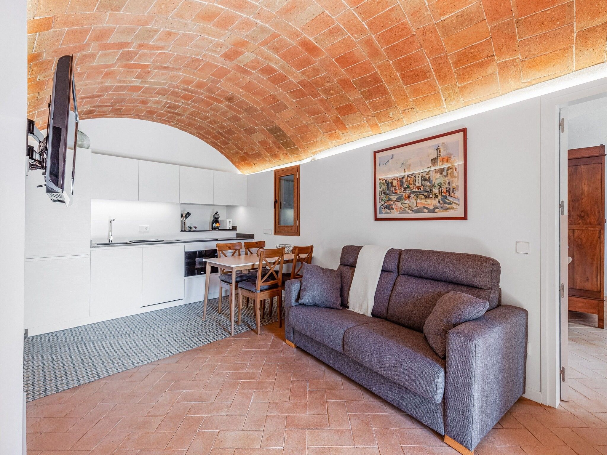 Un espacio habitable funcional con cocina, comedor y sofá.