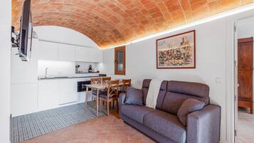 Un espacio habitable funcional con cocina, comedor y sofá.