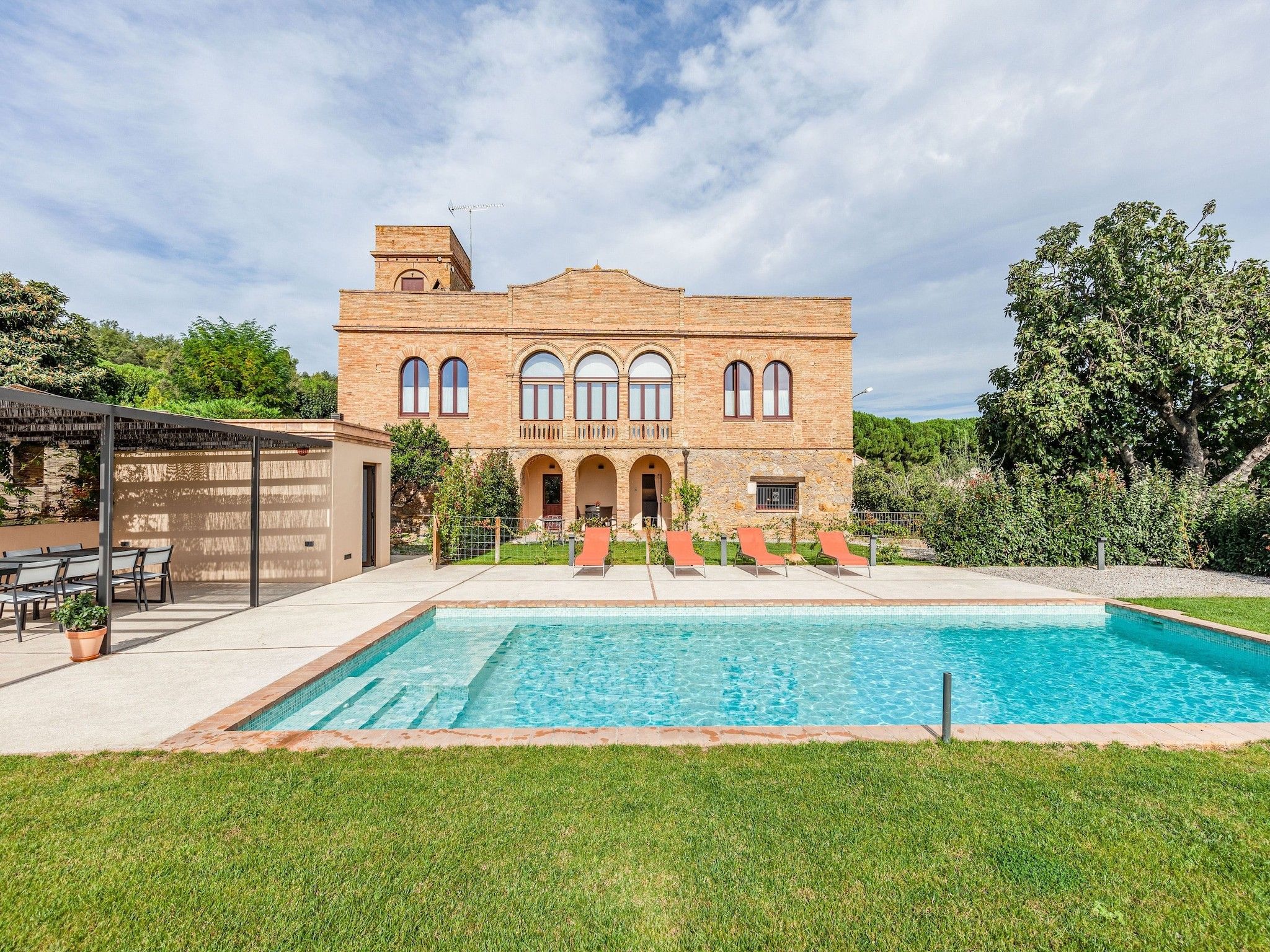 A large brick building with a swimming pool in front.