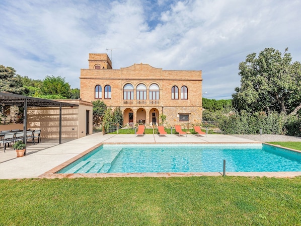 A large brick building with a swimming pool in front. - Apartment 'Mas Moré Petit' with Shared Pool, Wi-Fi and Air Conditioning (Vulpellac)