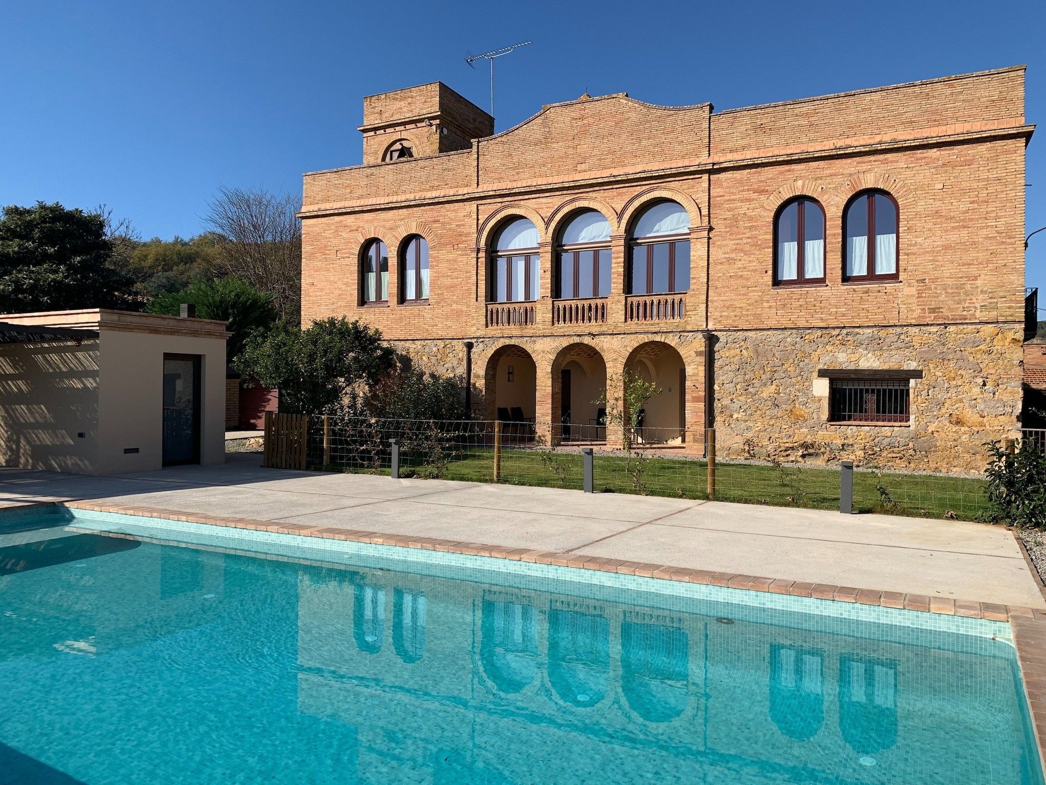 A two-story building with a swimming pool in front.