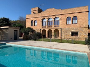 Un bâtiment à deux étages avec une piscine devant.
