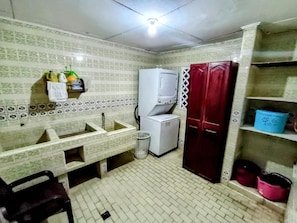 A compact kitchen with a sink, a refrigerator, and a cabinet with shelves. - Hostal Portones de Getsemaní (Cartagena de Indias)