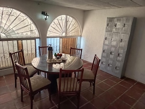 A dining area with a round table, six chairs, and a decorative centerpiece. - Hostal Portones de Getsemaní (Cartagena de Indias)