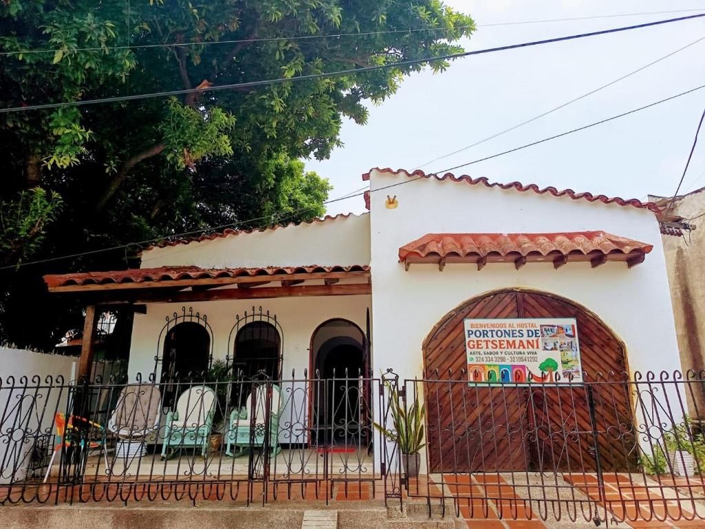 Um edifício com telhado em tijolos, portão e placa de identificação.