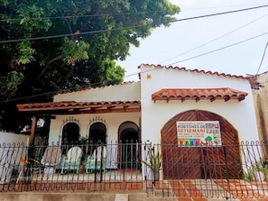 A building with a tiled roof, a gated entrance, and a signboard. - Hostal Portones de Getsemaní (Cartagena de Indias)