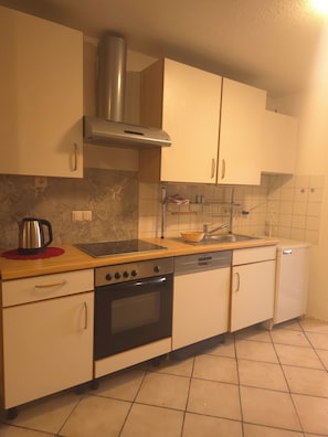 A kitchen with a stove, oven, sink, and dishwasher. - Vollmöbliertes 4-Zimmer-Haus in Pforzheim (Pforzheim)