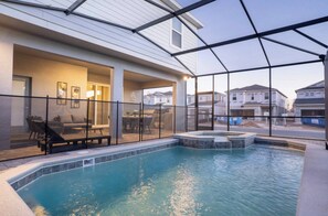 En privat pool med tillhörande bubbelbad, utomhusmöbler och en täckt uteplats.