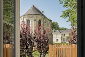 A building with a dome and arched windows, surrounded by a wooden fence and trees.