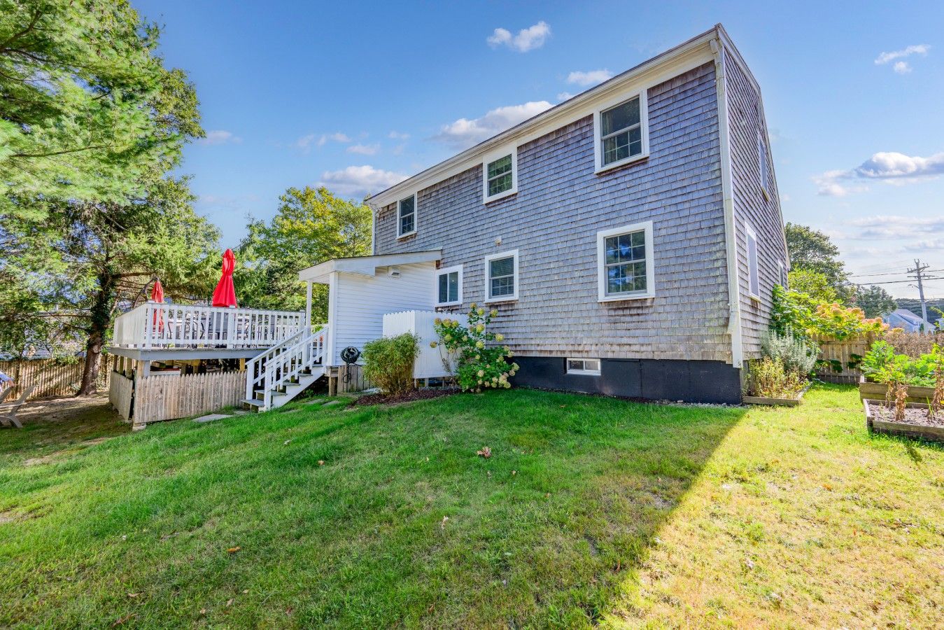 A two-story house with a covered porch and a fenced yard.