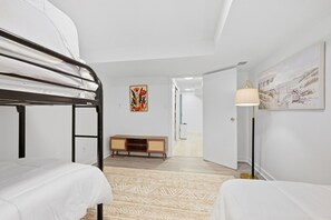 A bedroom with bunk beds, a wooden cabinet, a patterned rug, and a painting on the wall. - Falmouth Group Retreat, Outdoor Living, Central AC, Dogs OK (Falmouth)