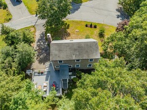 A two-story building with a deck and outdoor seating area. - Falmouth Group Retreat, Outdoor Living, Central AC, Dogs OK (Falmouth)