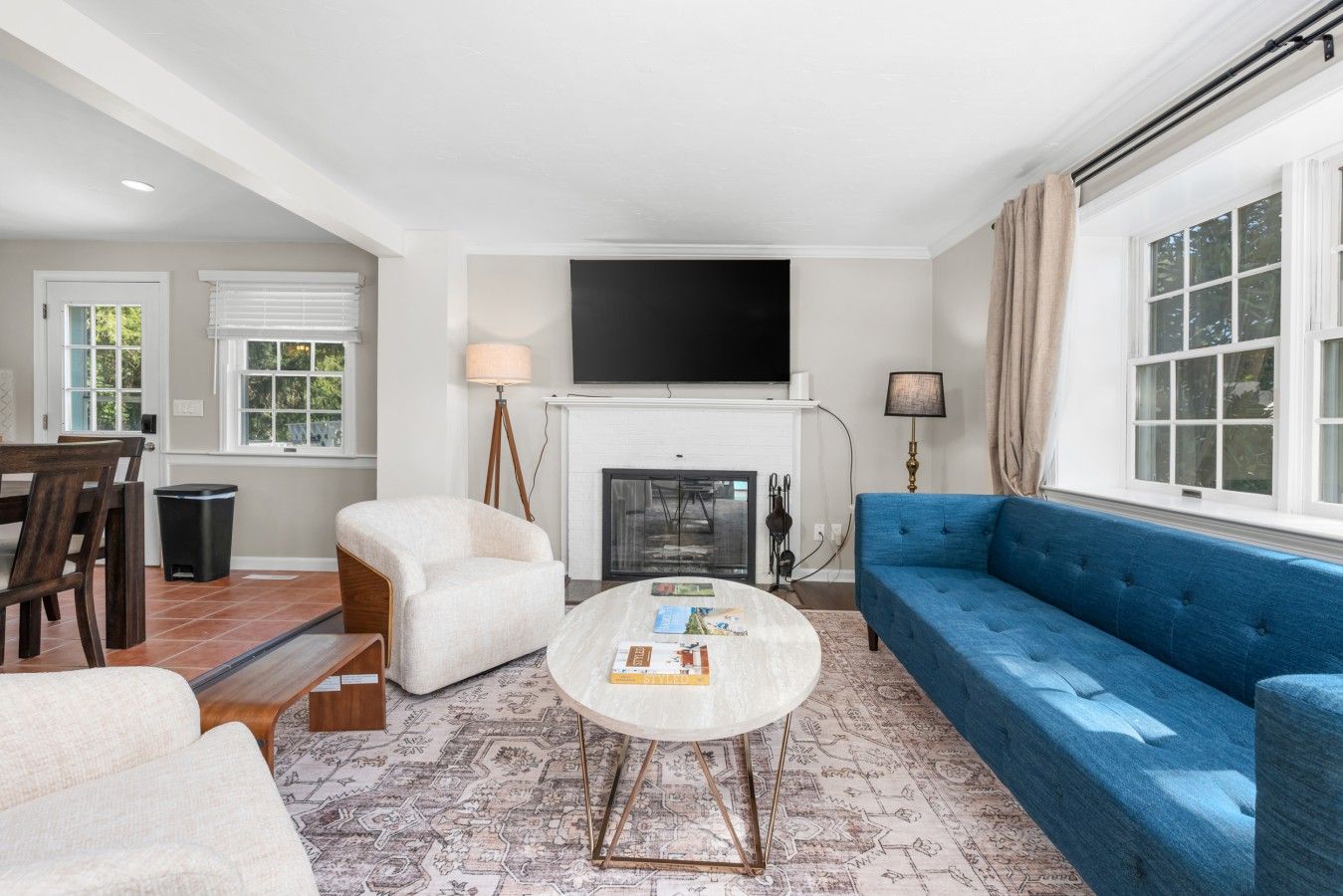 A living room with a fireplace, a sofa, a coffee table, and a television mounted above the fireplace.