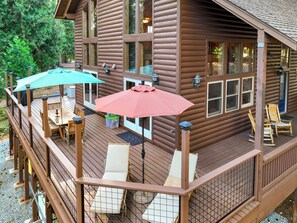 A wooden cabin with a deck, outdoor seating, and a covered patio area. - Family & Dog Friendly Pollock Pines Cabin near Jenkinson Lake & Tahoe (Pollock Pines)
