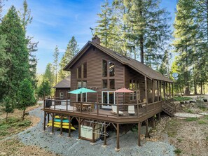 A wooden cabin with a deck, large windows, and outdoor seating. - Family & Dog Friendly Pollock Pines Cabin near Jenkinson Lake & Tahoe (Pollock Pines)