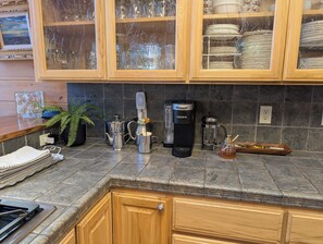 A kitchen with wooden cabinets, a coffee maker, a kettle, and a honey jar. - Family & Dog Friendly Pollock Pines Cabin near Jenkinson Lake & Tahoe (Pollock Pines)