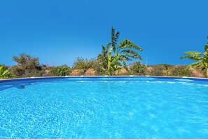 A clear blue swimming pool surrounded by lush greenery and a clear sky. - Torretta Morelli by BarbarHouse (Sannicola)