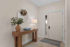 A wooden console table with a vase, a lamp, and a mirror against a wall. - Lakeside Leisure - Lake Views (Branson)