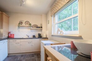 Eine Küche mit Fenster, Spüle und Arbeitsplatte.
