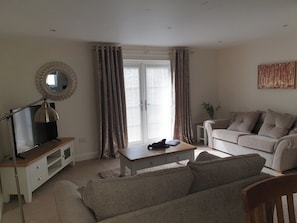 A living room with a television, sofa, and a coffee table. - 3 Dorcha's Mian - 2 Bedroom House, Killin (Stirling)
