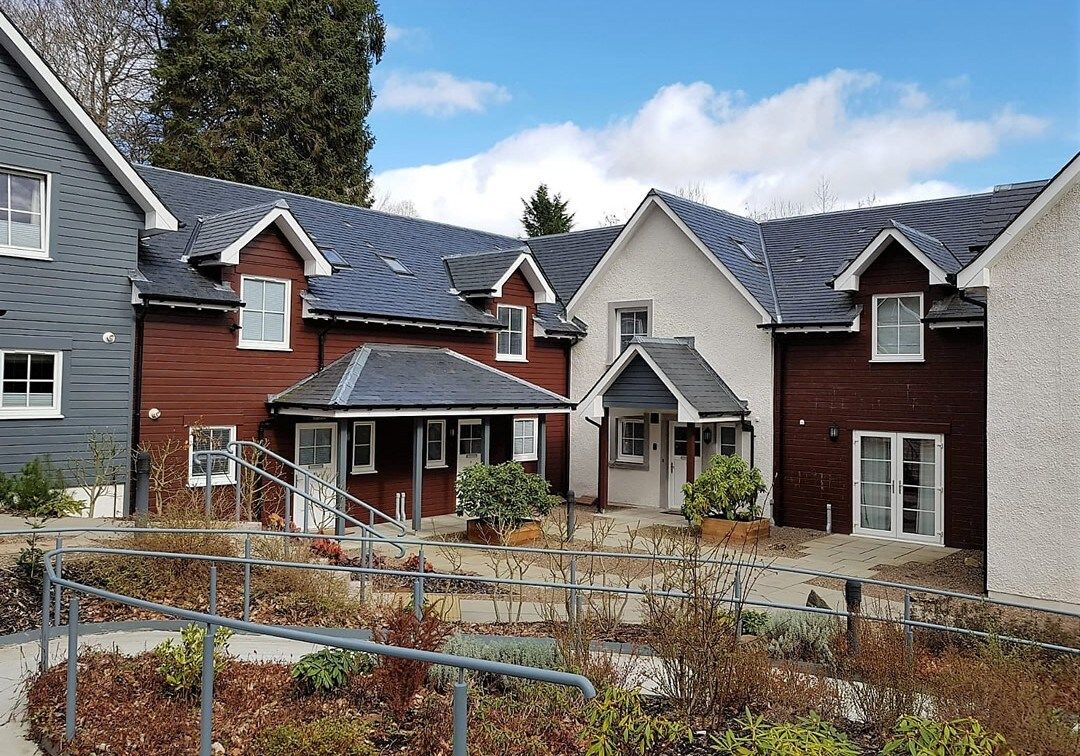 A residential complex with multiple houses, a central courtyard, and a metal staircase.