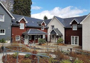 A residential complex with multiple houses, a central courtyard, and a metal staircase. - 9 Inverfinn - 2 Bedroom House Killin (Stirling)