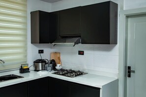 A modern kitchen with a gas stove, a coffee maker, and a kettle.