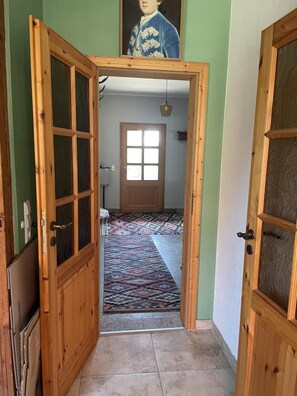 A hallway with a patterned carpet, wooden doors, and a framed portrait on the wall. - NEW! Elbenau Vacation Home (Elbenau)