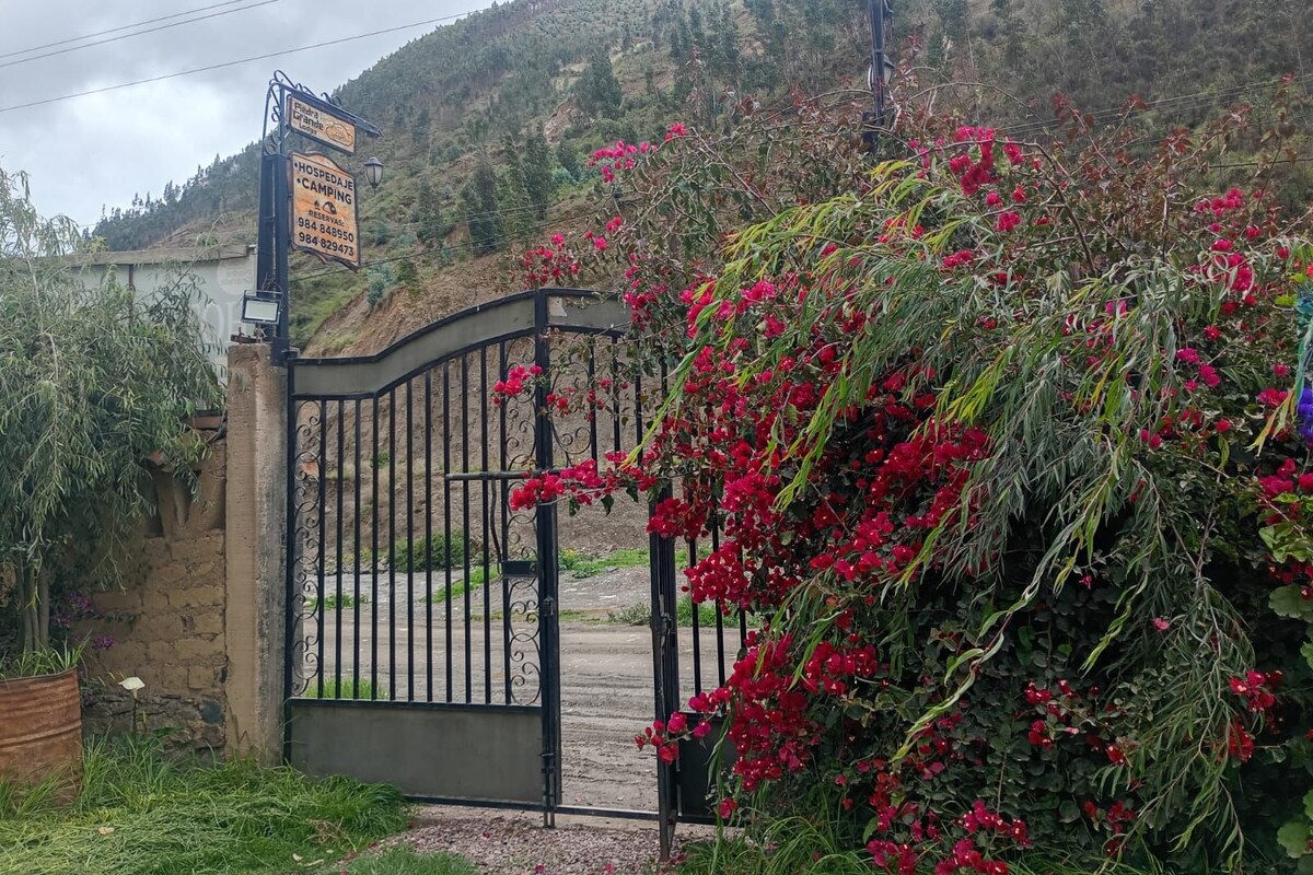 A gated entrance with a sign indicating a hotel and camping area.