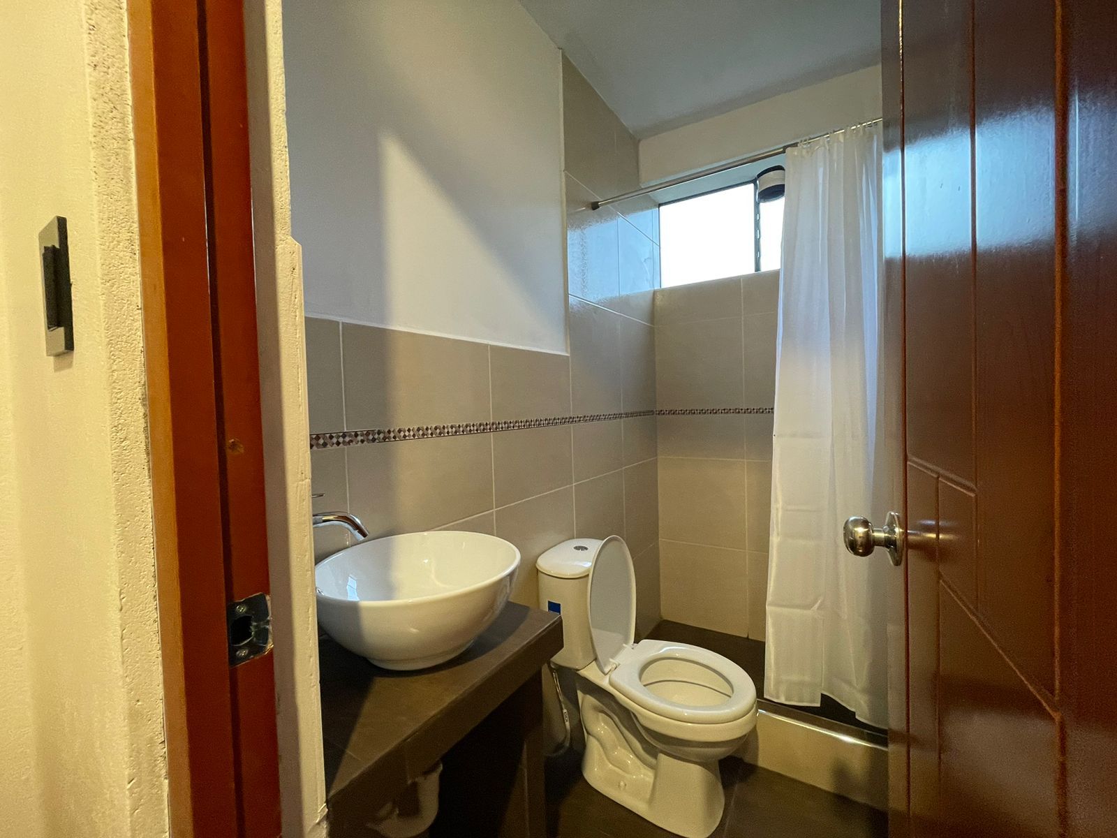 A bathroom with a toilet, sink, and shower.