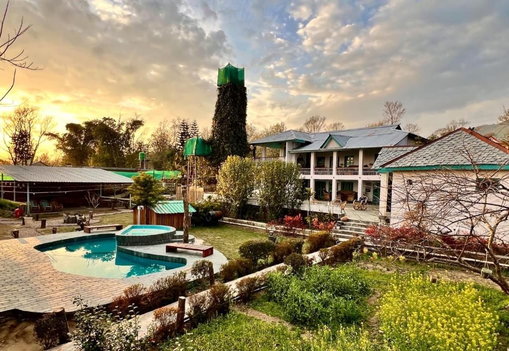 Una zona residencial con piscina, una estructura alta de color verde y una casa con balcón.