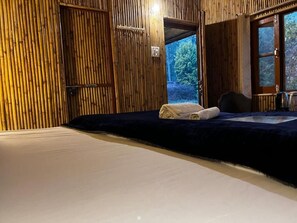 Una habitación con cama, una puerta de madera y vistas al exterior.