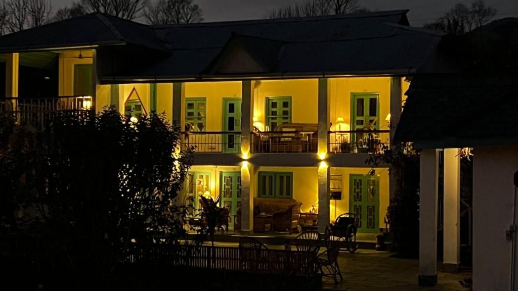 A two-story building with a balcony on the upper floor, a covered porch on the ground floor, and a visible entrance.