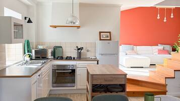 Een moderne keuken met witte kasten, een houten eettafel en een groene vaas.